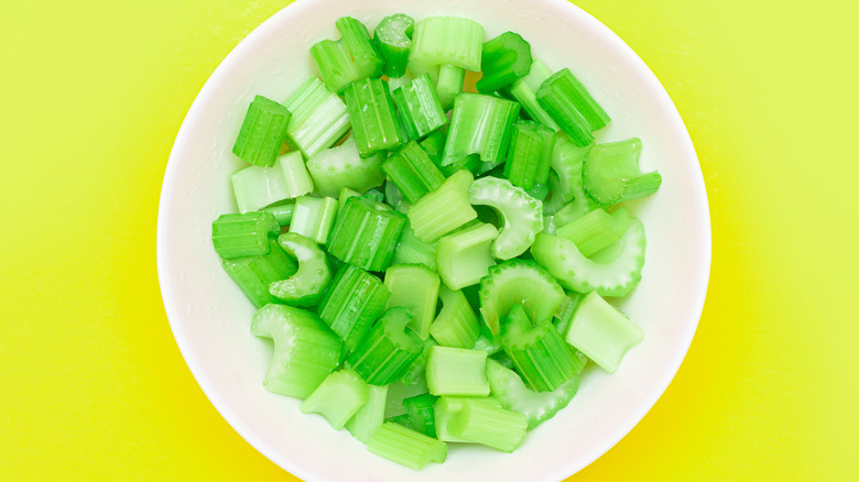celery in bowl with yellow background