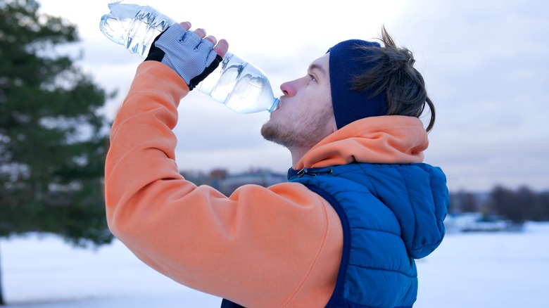 man drinking water during winter