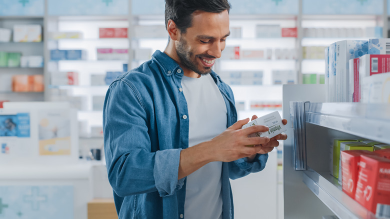 smiling man looking at medication