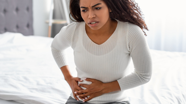 pained woman touching her lower abdomen