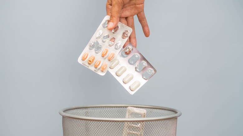 hand disposing medications in waste bin