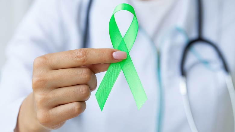 Doctor holding a lime green ribbon for Lyme disease awareness