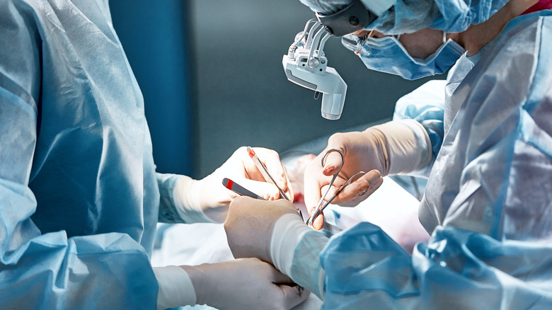 Two doctors operating on a patient