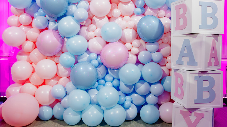 blue and pink balloons and large blocks that spell baby