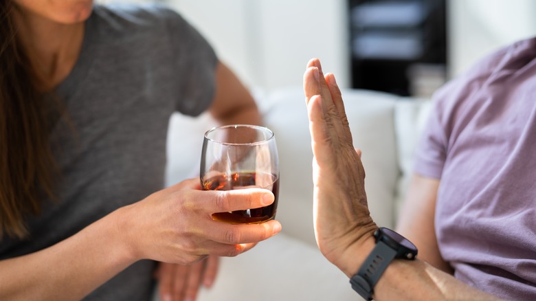 person refusing a glass of alcohol