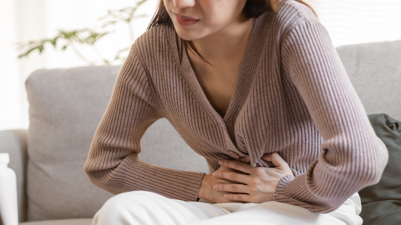 Woman crouched, holding abdomen