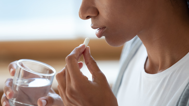 woman drinking water pills