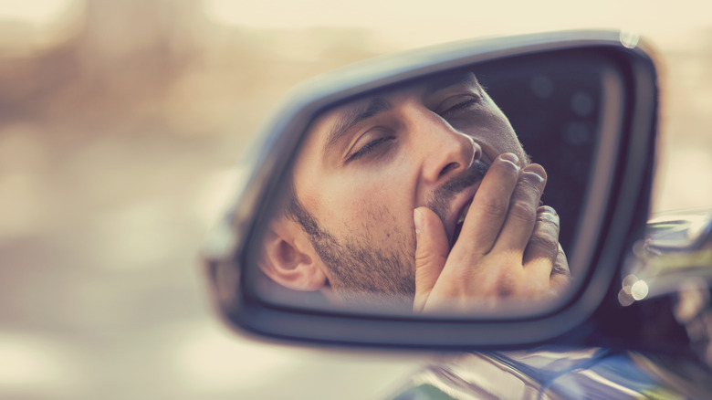 man yawning side mirror