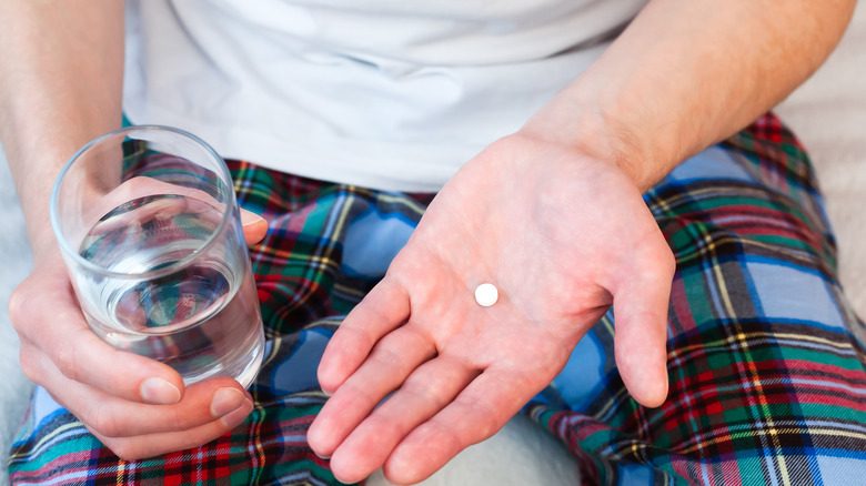 man with pill and water