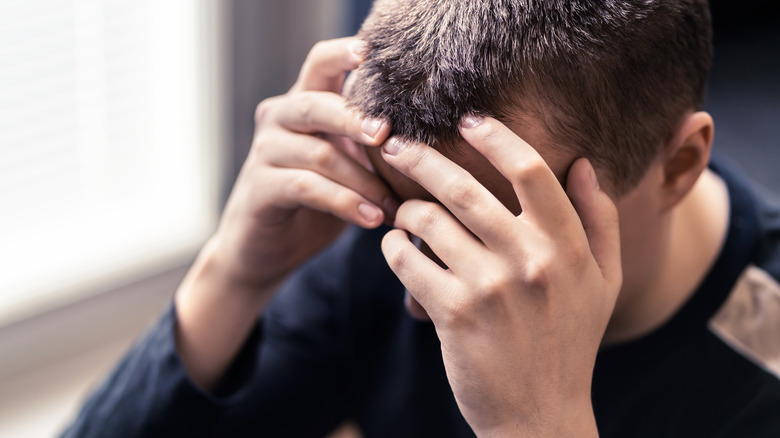 anxious man holding his head