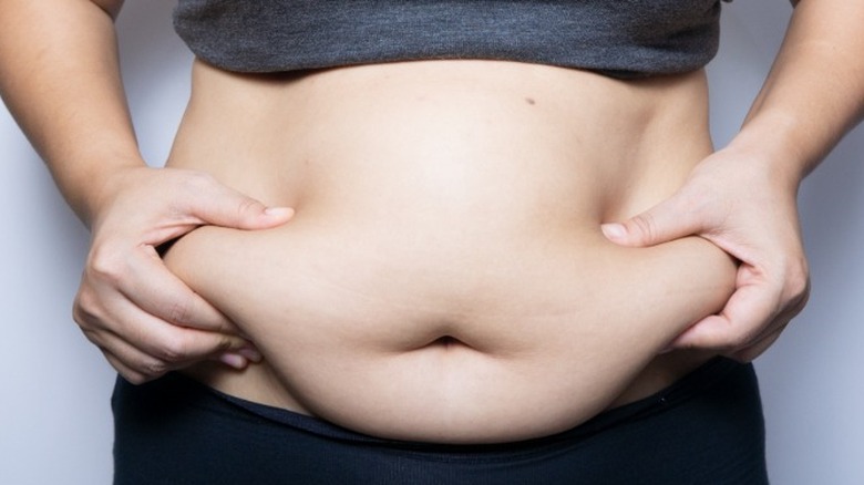 Woman grabbing belly fat
