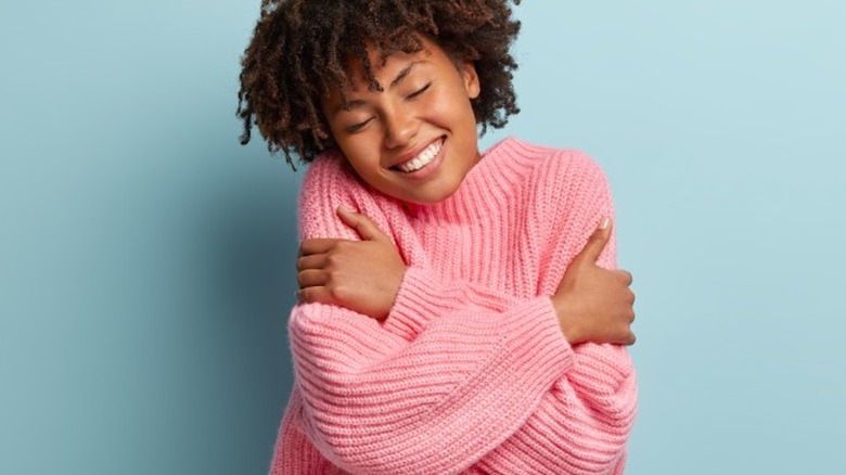 Young woman hugging herself