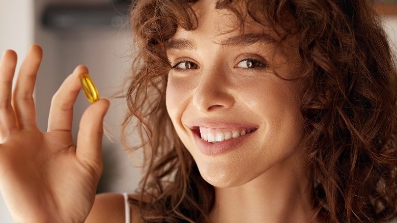 Young woman holding a supplement