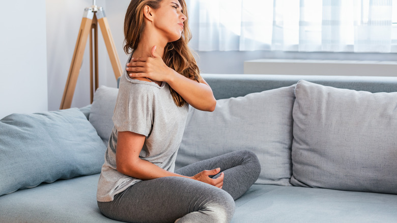 Seated women holding back of neck