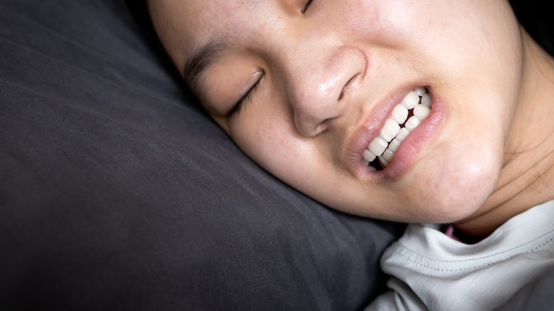 girl grinds teeth in bed