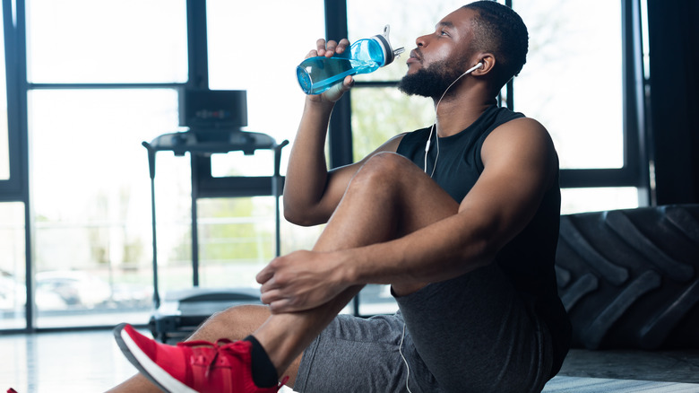 man drinking water in gym