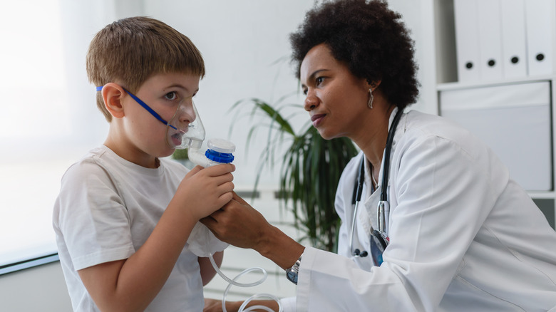 Doctor helps child use nebulizer