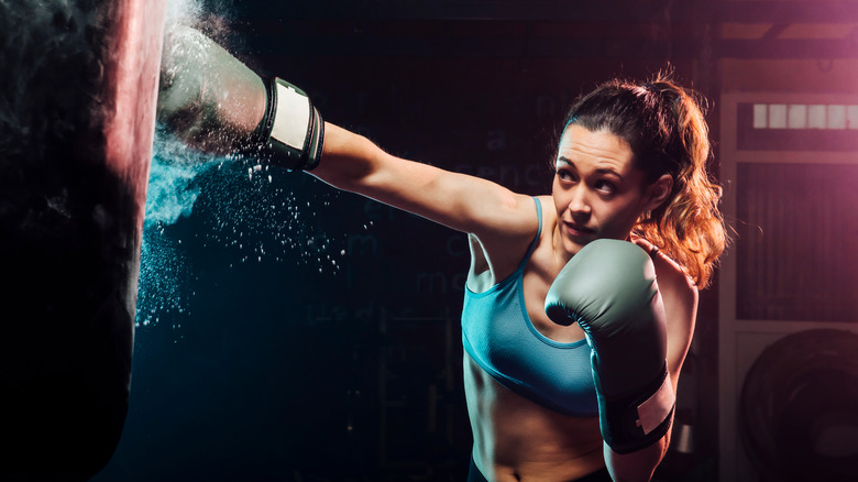 woman boxing against a training pad