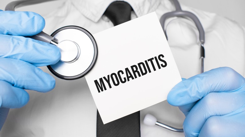 Doctor holding sign reading "MYOCARDITIS"