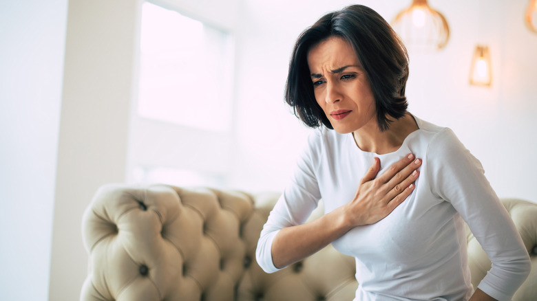 A woman holds her chest