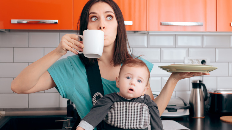woman holding coffee with plate and baby
