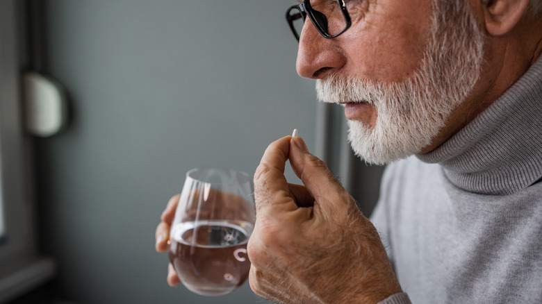 Bearded man taking a pill