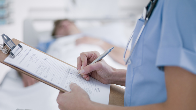 Nurse filling in patient's information chart