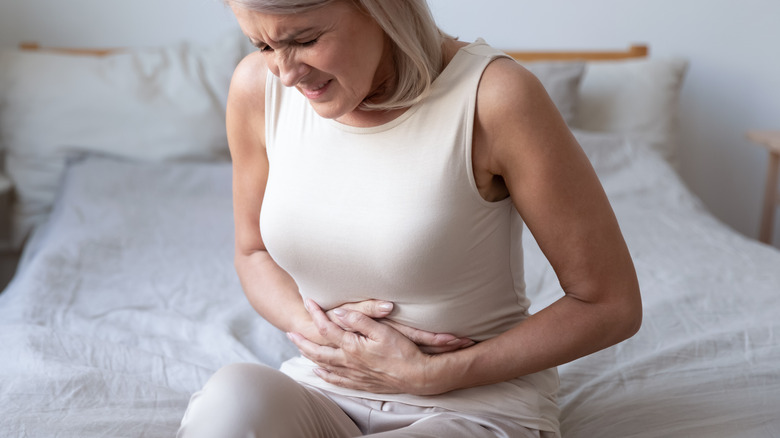 Woman clutching stomach in pain