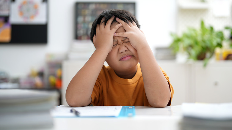 Young boy struggling with homework