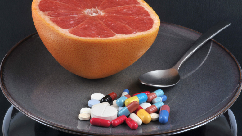Grapefruit on a plate with several types of drugs