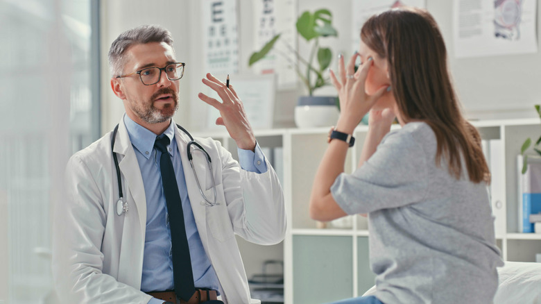 Woman with headache talking to doctor