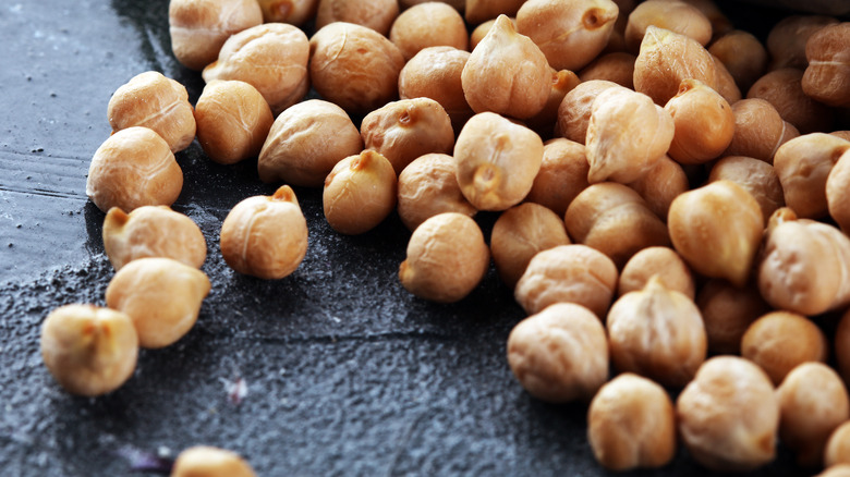 Chickpeas spread out on gray surface 