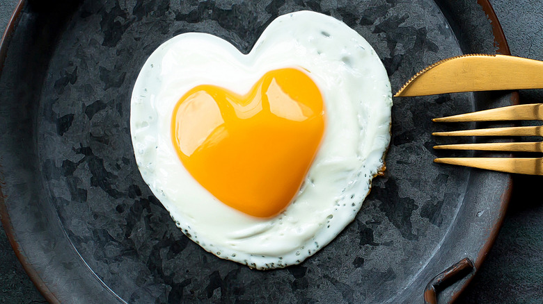 Egg yolk in a skillet shaped like a heart