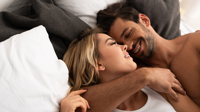 Man and woman cuddling in bed