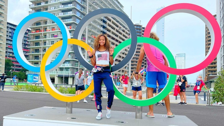 Gabbi Cunningham in front of the Olympic Rings in the Olympic Village