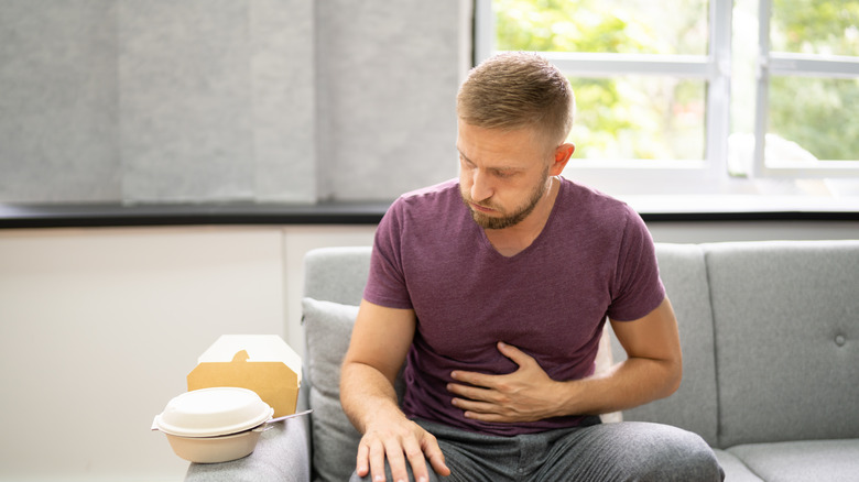 man suffering from heartburn after eating fast food