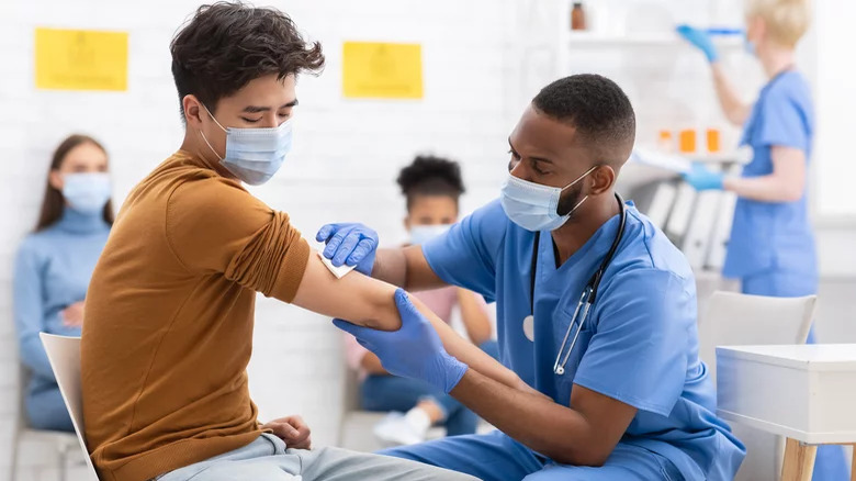 a man getting a vaccine from a friendly healthcare professional
