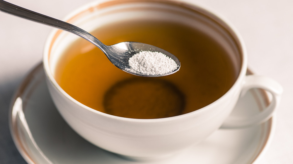 Cup of tea with artificial sweetener on spoon