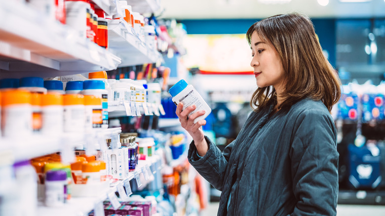 woman examining supplements in store