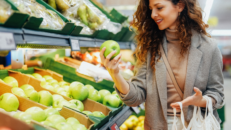 woman choosing fruits at grocery store