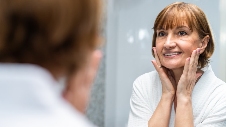 woman rubbing cream into face