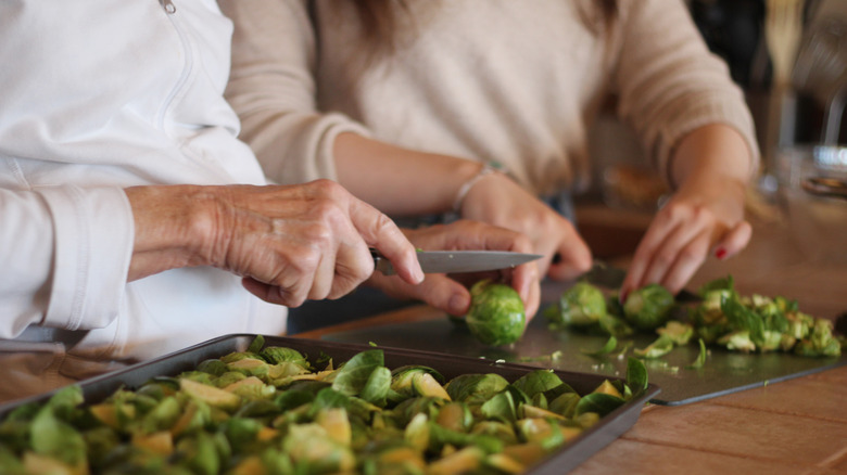 Women's hands chopping Brussels sprouts