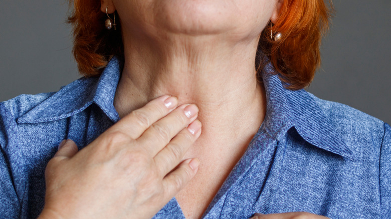 Woman with hand on thyroid