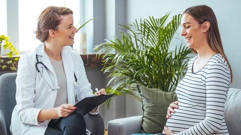 pregnant woman consulting with doctor 