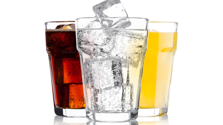 three soft drinks against a white background