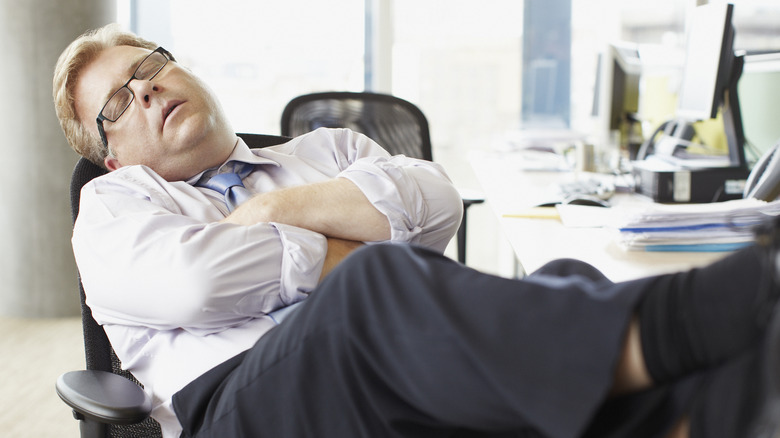 man asleep at his desk at work