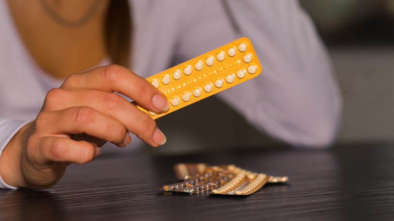 Woman holding birth control pills