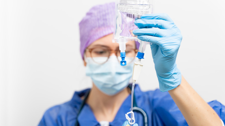 medical professional sets up an IV bag