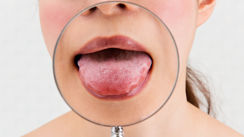 woman with her tongue in magnifying glass