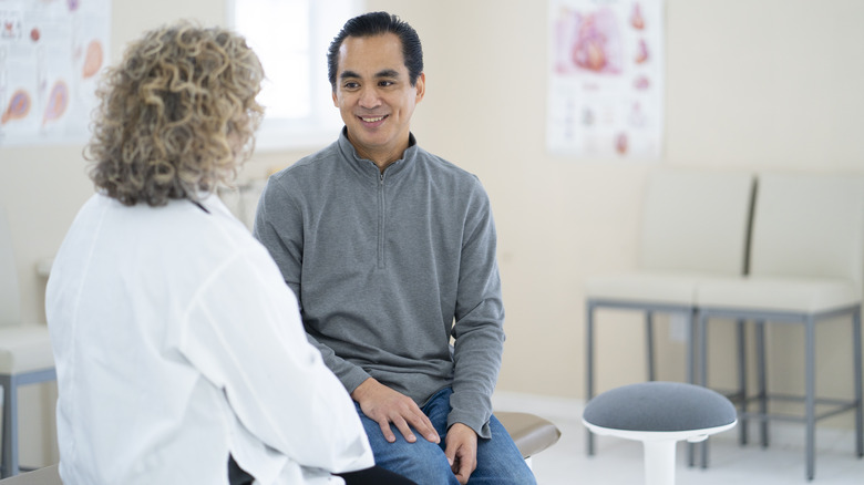 Smiling man talking to doctor